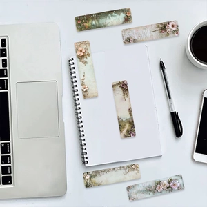 Flat lay of retro floral paper bookmarks with artistic landscape designs on a white desk