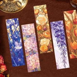 Macro detail of five stained glass floral bookmarks arranged on a textured surface