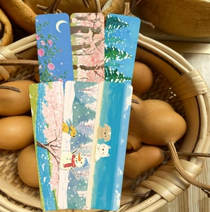 Segnalibri artistici con illustrazioni naturali in un cesto intrecciato con zucche