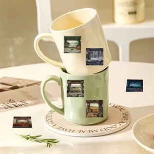 Detail of ceramic mugs with nature landscape stickers on a decorative coaster