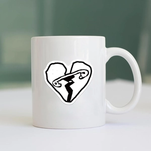Gros plan d'un mug en céramique avec graphique de cœur et épingle de nourrice