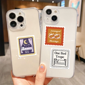 Stamp-style stickers with book trope themes displayed on transparent phone cases