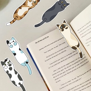 Dettaglio di cinque segnalibri a forma di gatto su un libro aperto per scrapbooking fai-da-te