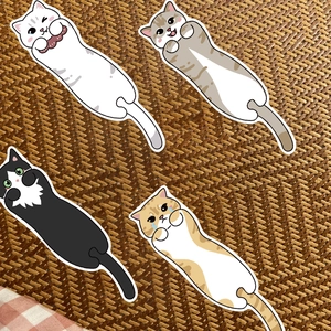 Primo piano di quattro simpatici segnalibri a gatto su uno sfondo intrecciato rustico