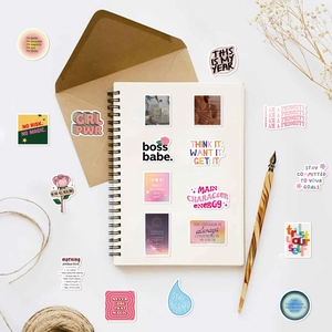 Flat lay of motivational stickers with Macaron colors on a notebook and stationery