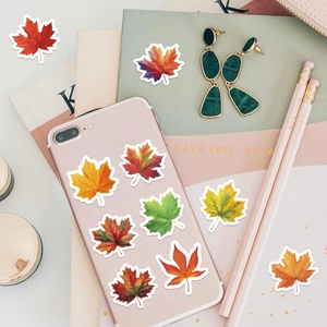 Adesivi a forma di foglia d'acero in rotolo per scrapbooking vicino a un laptop