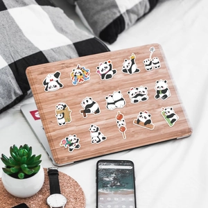 Pegatinas de panda impermeables mostradas en la tapa de un portátil en un entorno acogedor