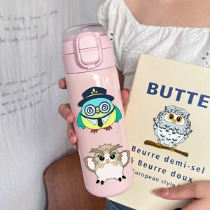 Pink thermal tumbler held by hand featuring cute owl prints and push-button lid