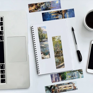 Künstlerische Ölgemälde-Lesezeichen auf Notizbuch mit Büroaccessoires im Hintergrund