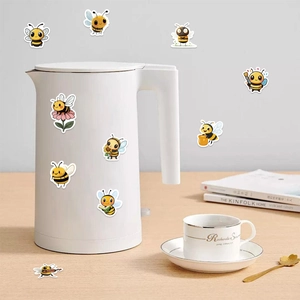 Cute honey bee stickers with various poses applied on a white kettle surface for decoration