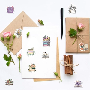 Flat lay of floral and book stickers decorating craft envelopes and gift boxes