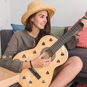 Poop emoji stickers applied on a guitar for creative DIY personalization and decoration
