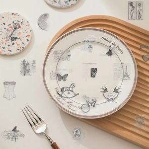 Dettaglio di piatto vintage in ceramica francese con farfalla e Torre Eiffel su vassoio