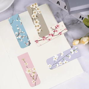 Set de marcapáginas magnéticos florales en cinco colores pastel sobre un cuaderno blanco