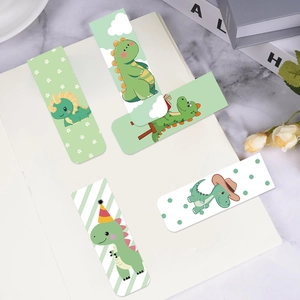 Five cute cartoon dinosaur magnetic bookmarks set on a minimalist white notebook