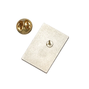 Detail of golden metal brooch back with butterfly clutch and textured matte finish