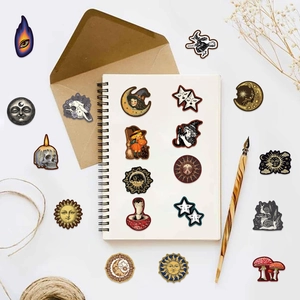 Close-up of vintage celestial stickers with moon and sun designs on a white notebook