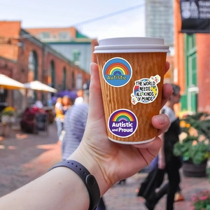 Détail des stickers autisme sur tasse à café avec motifs de puzzle arc-en-ciel