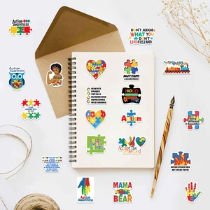 Vue détaillée des autocollants autisme sur carnet avec motifs de cœur en puzzle