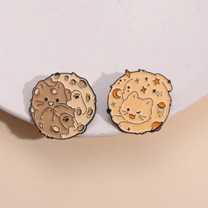 Cute galaxy cat enamel pins with moon and star celestial designs on a white plate