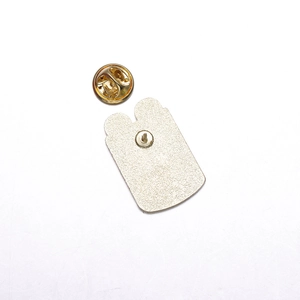 Detailed view of silver pin base and golden butterfly clutch back for cartoon metal badge