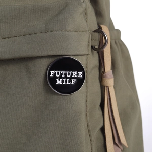 Classic round black enamel brooch pin featuring white FUTURE MILF lettering and silver edge