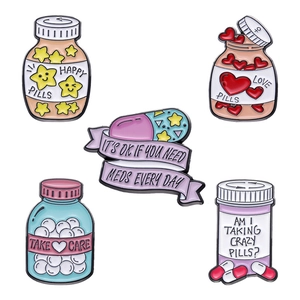 Pastel enamel pins set featuring medicine bottles and pills with positive messages