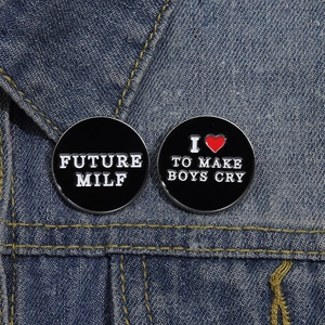 Classic black enamel pins with FUTURE MILF and heart quotes on blue denim jacket