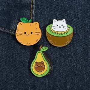 Lot de trois pin's émaillés chats et fruits mignons sur un tissu en denim bleu
