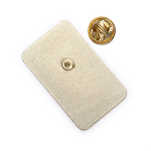 Macro shot of gold-plated metal brooch back with butterfly clasp and textured finish