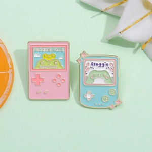 Retro gaming console enamel pin set featuring cute frog designs in pink and light blue