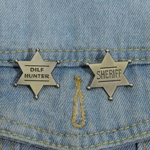 Detail of vintage star-shaped metal sheriff badges pinned on a blue denim jacket pocket
