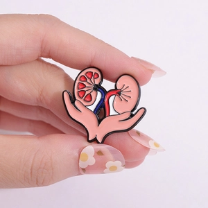Anatomische Nieren-Emaille-Anstecknadel auf rosa Hintergrund für medizinische Mode