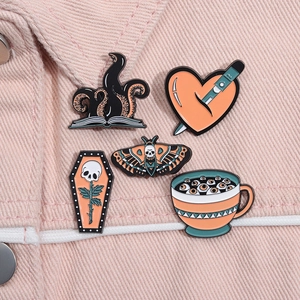 Close-up of five gothic enamel pins featuring skull moth and heart dagger on a jacket