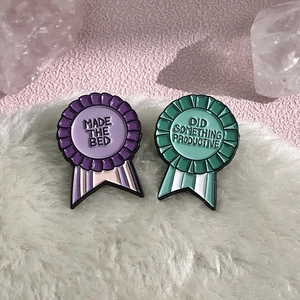 Détail d'épingles en émail en forme de médaille sur fond pelucheux avec cristaux