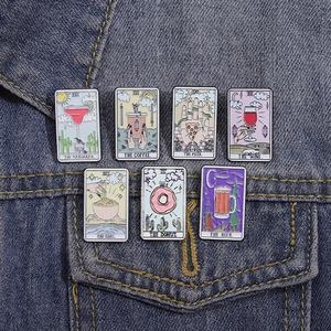 Close-up of seven tarot-inspired enamel pins with food themes on blue denim fabric
