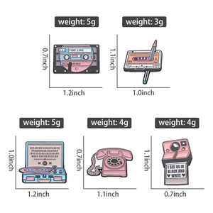 Close-up of retro pink enamel pins featuring vintage radio, camera, and tape designs