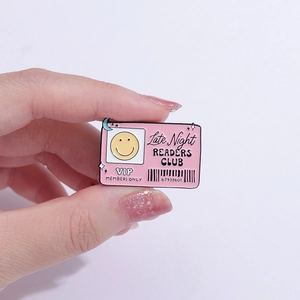 Late Night Readers Club enamel pin with a pink VIP card design and yellow smiley face