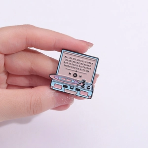 Macro detail of retro record player enamel pin featuring Heartbreak Weather lyrics