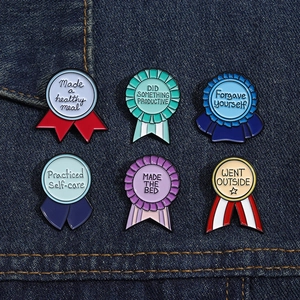 Vue rapprochée de badges médailles émaillés colorés avec citations sur fond en jean