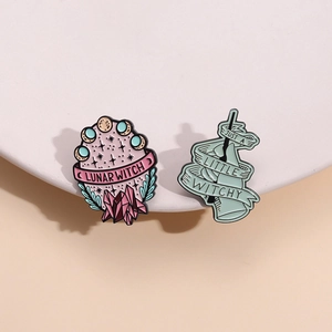 Lunar Witch and Witchy enamel pins set with moon phases and crystal designs on a white stand