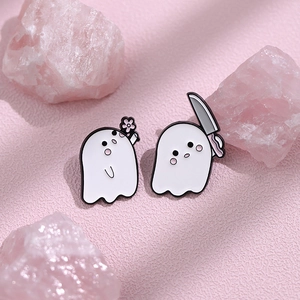 Détail de broches en émail de petits fantômes blancs mignons sur fond rose texturé