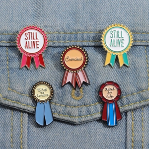 Détail de cinq pin's émaillés colorés style médaille épinglés sur une veste en jean