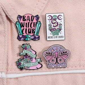 Detailed set of 4 enamel witch and nature pins with inspirational text on pink denim