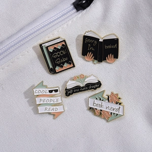 Five-piece book nerd enamel pin set with floral and literary slogans on canvas bag
