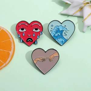 Set di tre spille creative a cuore in smalto con motivi a onde, teschi e mani d'arte