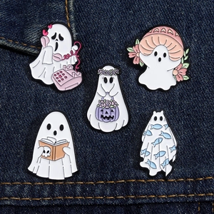 Dettaglio di cinque spille smaltate a forma di fantasma di Halloween su tessuto denim