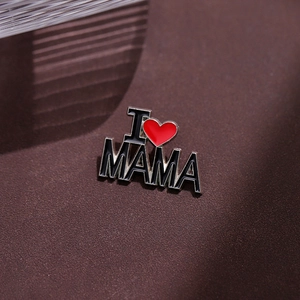 Vista macro della spilla I Love Mama con cuore rosso su smalto nero e metallo argento