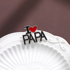 Détail de la broche émaillée 'I LOVE PAPA' avec lettres noires et un cœur rouge vif