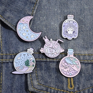 Detail von fünf süßen Emaille-Pins mit Katzen und Hasen auf einem Denim-Hintergrund